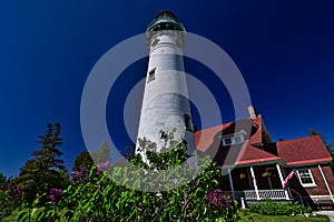 Seul Choix Point Lighthouse and keepers home behind blooming flowers