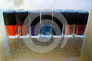 Seven bottles of nail polish on a table