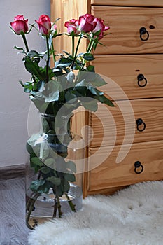 Seven bouquets of roses in a vase built with wooden dressers