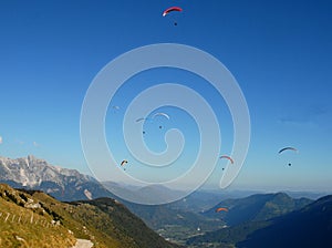Seven colorful hang-gliders in the blue sky