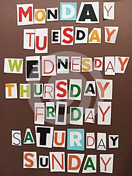 Seven days of the week written with colorful letters on a brown background