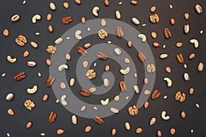 Seven different nuts on a black background pattern