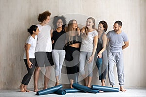 Seven diverse people wearing sportswear wait for yoga class training