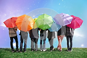 Seven friends with rainbow color umbrellas