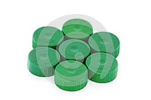 Seven green plastic bottle caps