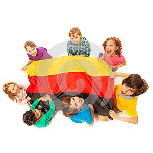 Seven kids holding German flag sitting around it