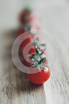 Seven micro tomatoes in a row on a wooden table