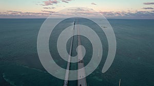 Seven Mile Bridge Tilt Up to Sunset in Florida Keys Aerial View. Fly Over American Bridge Over Blue Ocean Pastel Colored Sky