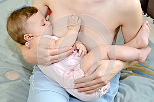 The seven-months child sleeps at a maternal breast. Breastfeeding