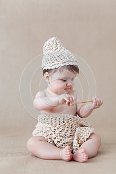 Baby girl playing with a wooden honey spoon