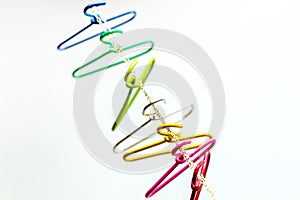 Seven multicolored clothes hangers hangs over the chain