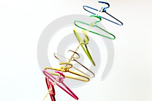 Seven multicolored clothes hangers hangs over the chain