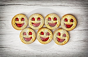 Seven round biscuits smiling faces, humorous food theme