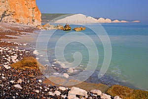 Seven Sisters cliffs uk with beach rocks and clear turquoise sea