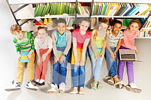 Seven smiling children sitting together on floor