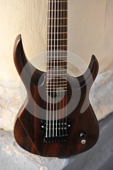 Seven-string electric guitar made of dark wood. Background for music and creativity