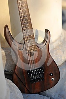 Seven-string electric guitar made of dark wood. Background for music and creativity