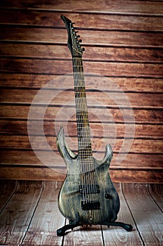 Seven-string electric guitar made of dark wood. Background for music and creativity