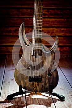 Seven-string electric guitar made of dark wood. Background for music and creativity