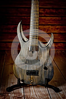 Seven-string electric guitar made of dark wood. Background for music and creativity