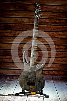 Seven-string electric guitar made of dark wood. Background for music and creativity