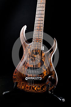 Seven-string electric guitar made of dark wood. Background for music and creativity