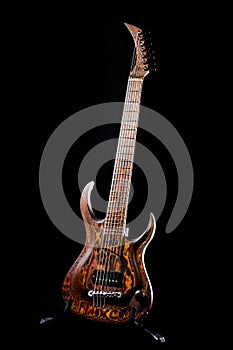 Seven-string electric guitar made of dark wood. Background for music and creativity