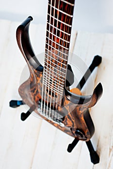 Seven-string electric guitar made of dark wood. Shot on a white background. Background for music and creativity