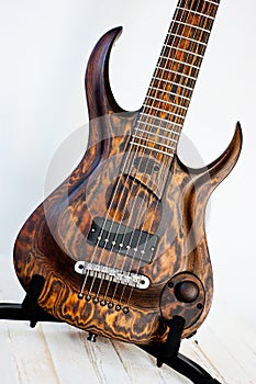 Seven-string electric guitar made of dark wood. Shot on a white background. Background for music and creativity