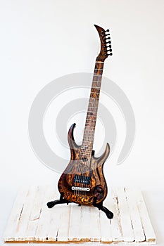 Seven-string electric guitar made of dark wood. Shot on a white background. Background for music and creativity