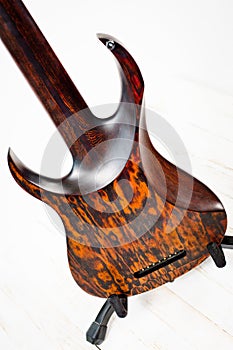 Seven-string electric guitar made of dark wood. Shot on a white background. Background for music and creativity