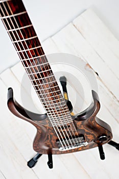 Seven-string electric guitar made of dark wood. Shot on a white background. Background for music and creativity