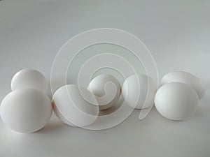 Seven White Eggs in a White Bowl against a White Background