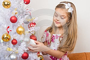 Seven-year girl in beautiful dress treats Christmas toys