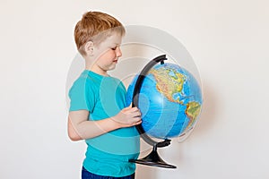 Seven-year-old Caucasian boy holding a large globe