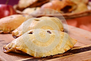 Several apple hand pies on a serving board and in a basket