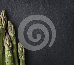 Several asparagus framing stone copyspace.