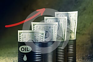 Several barrels of oil with dollars and a red arrow up - concept of higher oil prices