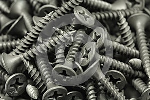 Several black anodized screws background