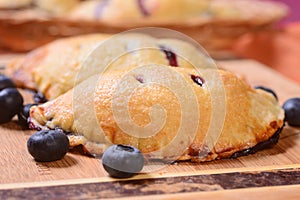 Several bleuberry hand pies on a serving board and in a basket