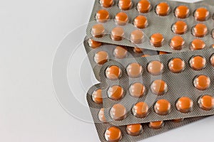 Several blisters with medicine pills on neutral white background. Pile of tablets, capsules