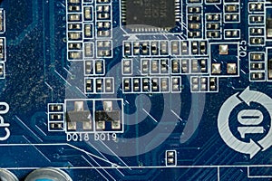 Several board microcircuits and transistors on the motherboard in a dusty personal computer close-up