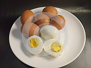 Several of boiled eggs in a white bowl and black background