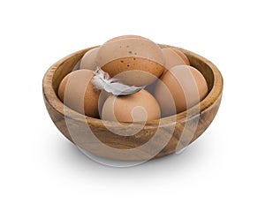 Several brown Eggs in wooden bowl isolated on white background
