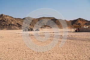 Several buggies are in line. Wonderful desert landscape with hills and beuatiful blue sky with clouds in background. It`s on