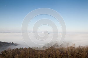 Several buildings in the fog with blue sky