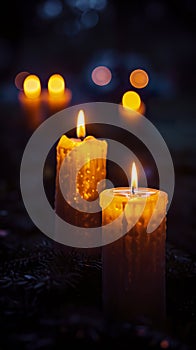 Several candles lit under a night vigil in a dark environment.