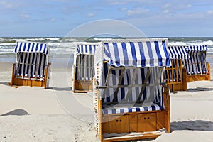 Several canopied beach chairs by a sea coast