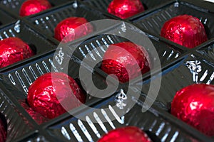 Several chocolates in red foil