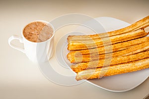 Several churros on small plate and milk with chocolate